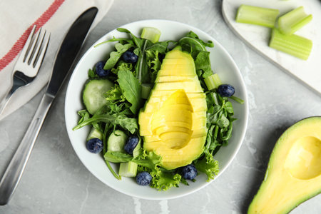 Delicious avocado salad with blueberries in bowl on gray marble table, flat layの写真素材
