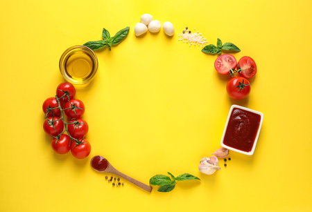 Flat lay composition with fresh pizza ingredients on yellow background. Space for textの写真素材