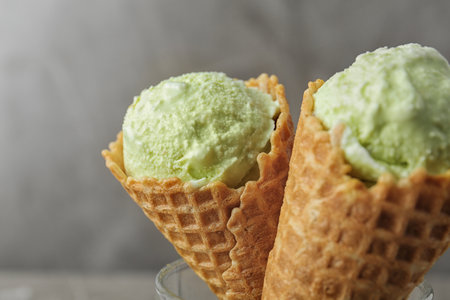Delicious pistachio ice cream on gray background, closeup