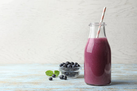 Fresh acai drink with berries on wooden table against light background. Space for textの写真素材