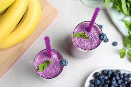 Flat lay composition with delicious blueberry smoothie on light marble tableの写真素材