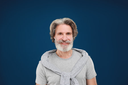 Portrait of handsome mature man on blue background