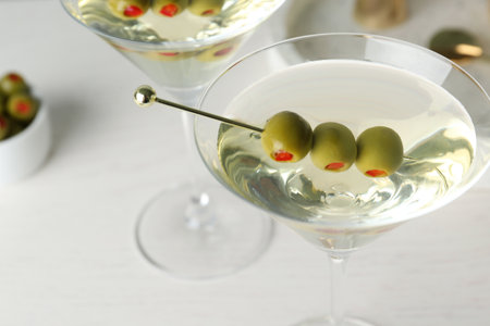 Glasses of Classic Dry Martini with olives on wooden table, closeupの写真素材