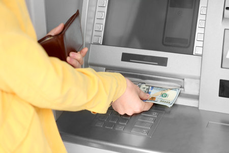 Woman taking money from cash machine outdoors, closeupの写真素材