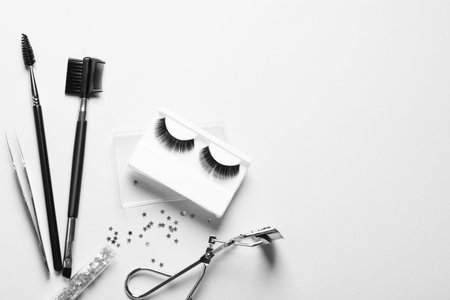 Composition with false eyelashes and tools on white background, top viewの写真素材