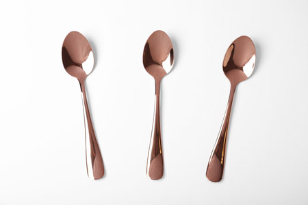 Set of new gold spoons on white background, top viewの写真素材