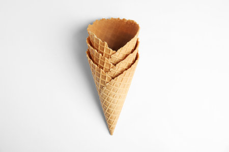 Empty wafer ice cream cones on white background, top view