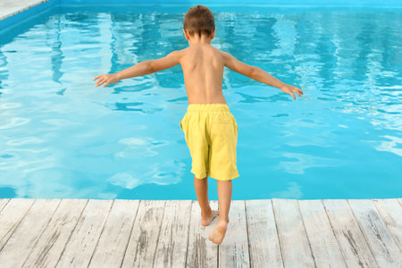 Little child near outdoor swimming pool. Dangerous situationの写真素材