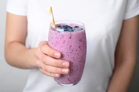 Woman holding glass of delicious blueberry smoothie, closeupの写真素材