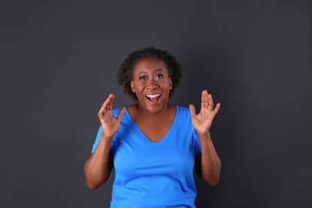 Portrait of happy African-American woman on black background