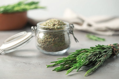 Fresh twigs and dried rosemary on gray tableの写真素材