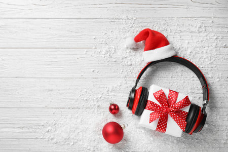 Flat lay composition with headphones on white wooden background, space for text. christmas music conceptの写真素材