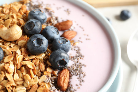 Bowl of tasty oatmeal with blueberries and yogurt on table, closeupの写真素材