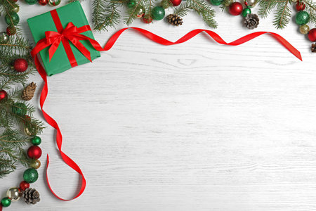 Flat lay composition with Christmas gift box on white wooden background. Space for text