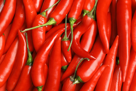 Ripe red chili peppers as background, top view
