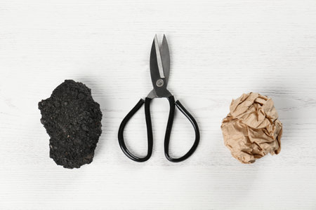 Flat lay composition with rock, paper and scissors on white wooden background