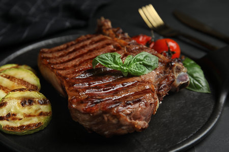 Board with grilled meat steak on black table, closeupの写真素材