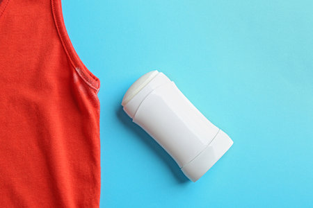 Clothes with stain and deodorant on light blue background, top viewの写真素材