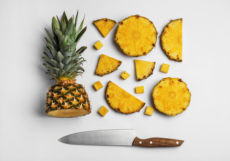 Composition with raw cut pineapple and knife on white background, top viewの写真素材