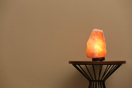 Himalayan salt lamp on table against  beige background. Space for textの写真素材