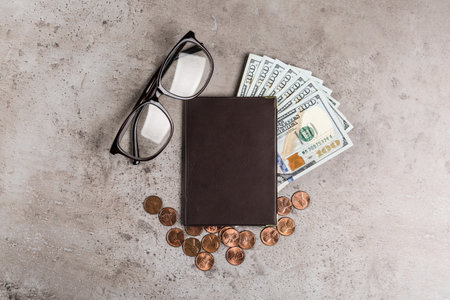 Pension certificate with American money and glasses on grey stone table, flat layの写真素材