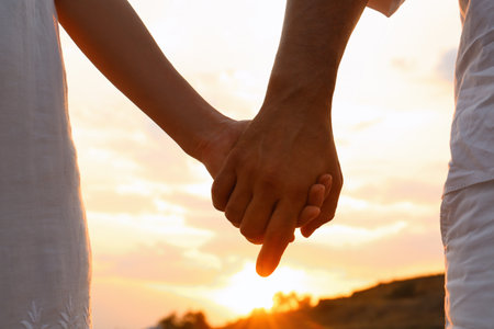 Romantic couple holding hands together on beach, closeup viewの写真素材