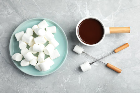 Fondue pot with dark chocolate and marshmallows on marble table, flat layの写真素材