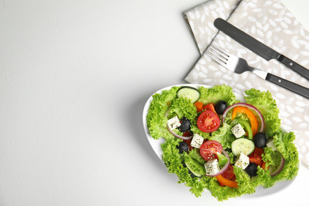 Tasty fresh Greek salad on white table, flat lay. Space for textの写真素材