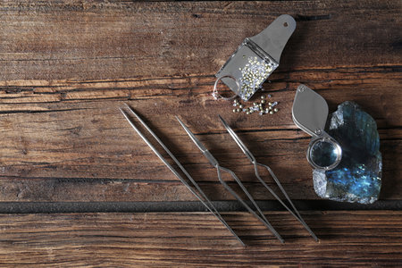 Flat lay composition with jewelry tools on wooden tableの写真素材