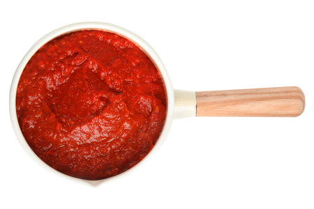 Delicious tomato sauce in pan isolated on white, top viewの写真素材