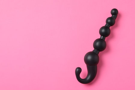 Black anal ball beads on pink background, top view with space for text. sex toyの写真素材
