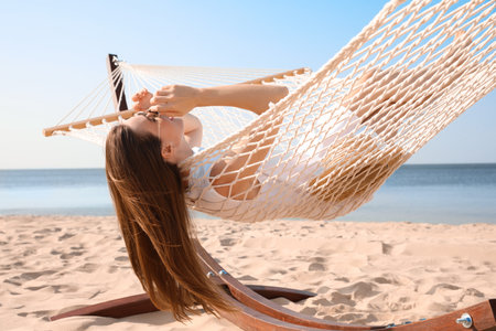 Young woman relaxing in hammock on the beachの写真素材