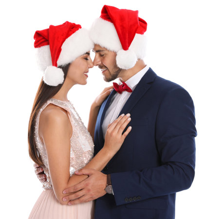 Lovely young couple in Santa hats on white background. christmas celebrationの写真素材