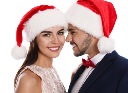 Lovely young couple in Santa hats on white background. christmas celebrationの写真素材