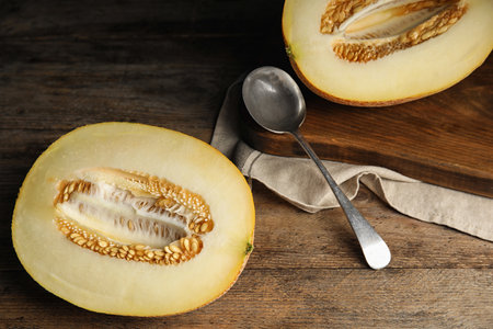 Halves of tasty ripe melon on wooden tableの写真素材