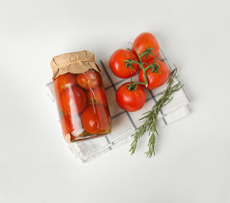 Flat lay composition with pickled tomatoes in glass jar on white tableの写真素材