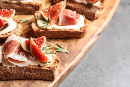 Bruschettas with cream cheese, prosciutto and figs on gray table, closeupの写真素材