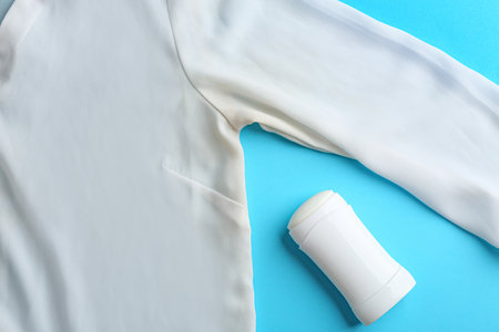 Clothes with stain and deodorant on light blue background, top viewの写真素材