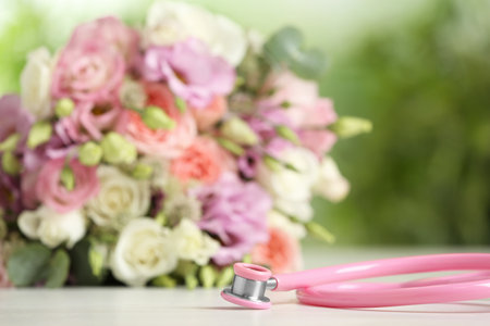 Stethoscope and flowers on white table against blurred background, space for text. world health dayの写真素材