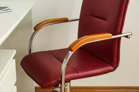 Modern office chair near table indoors, closeup. Stylish workplace interiorの写真素材