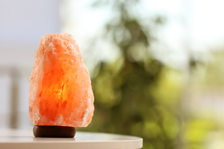 Himalayan salt lamp on table indoors, space for textの写真素材