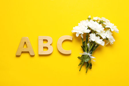 Flat lay composition with flowers and letters on yellow background. teacher's dayの写真素材