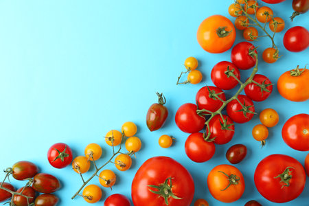 Flat lay composition with fresh ripe tomatoes on light blue background. Space for textの写真素材