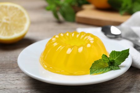 Delicious fresh yellow jelly with mint on wooden tableの写真素材