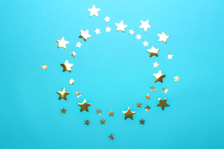 Frame made of confetti stars with space for text on blue background, top view. christmas celebration