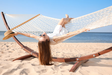 Young woman relaxing in hammock on the beachの写真素材