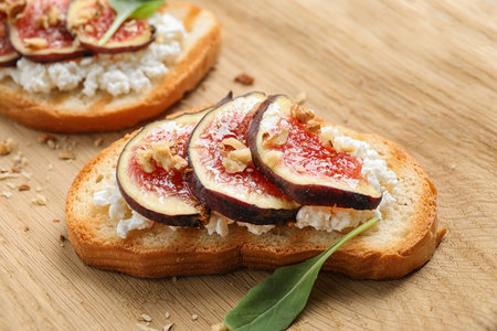 Bruschettas with cheese and figs on wooden board, closeup