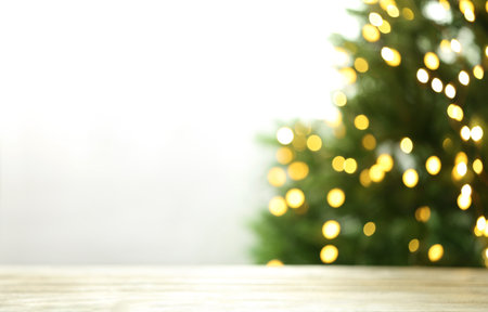 Empty table and blurred fir tree with yellow Christmas lights on background, bokeh effect. space for designの写真素材