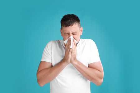 Man suffering from allergy on blue backgroundの写真素材
