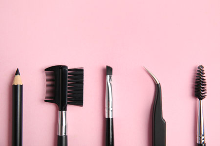 Set of professional eyebrow tools on pink background, flat layの写真素材